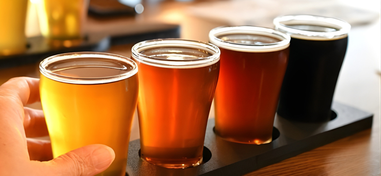 Flight of four different craft beers on a wooden serving platter