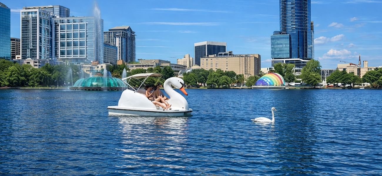 People ride a swan-shaped pedal boat in Lake Eola.