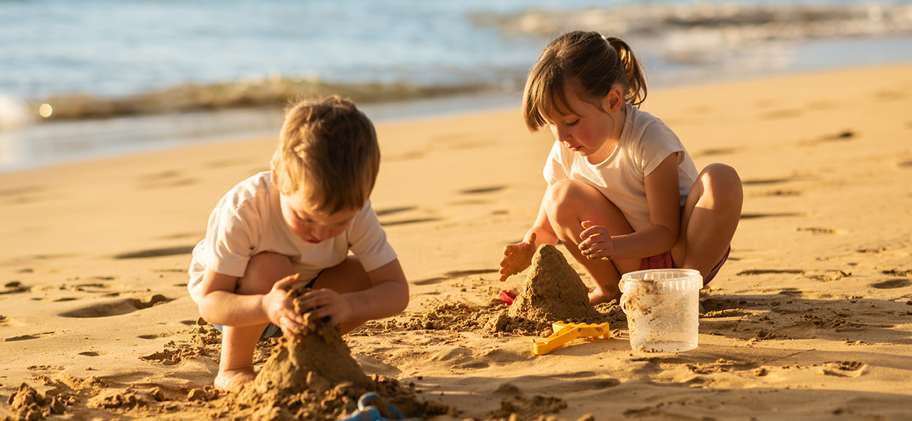 Kids playing in the sand at the beach.