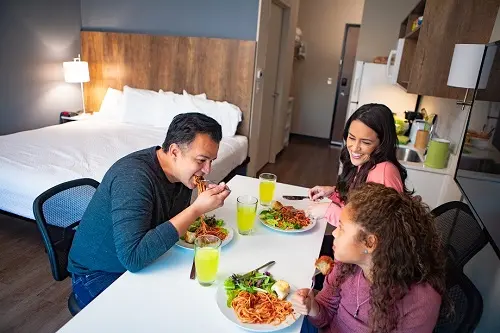 Family in their hotel room eating dinner