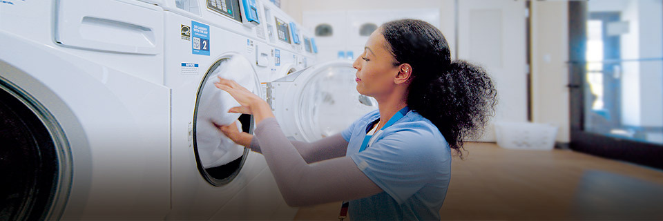 nurse doing laundry in hotel on-site guest laundry room
