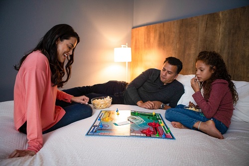 Family playing a board game in their hotel room